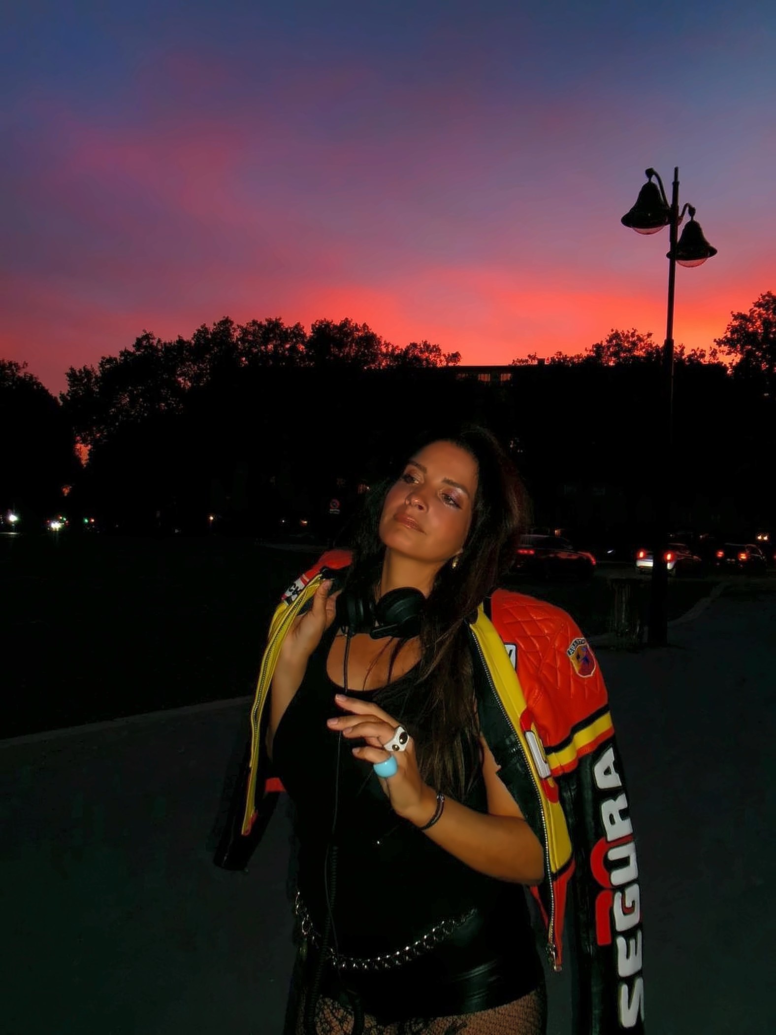 SEYA au coucher du soleil, casque de DJ autour du cou, veste moto