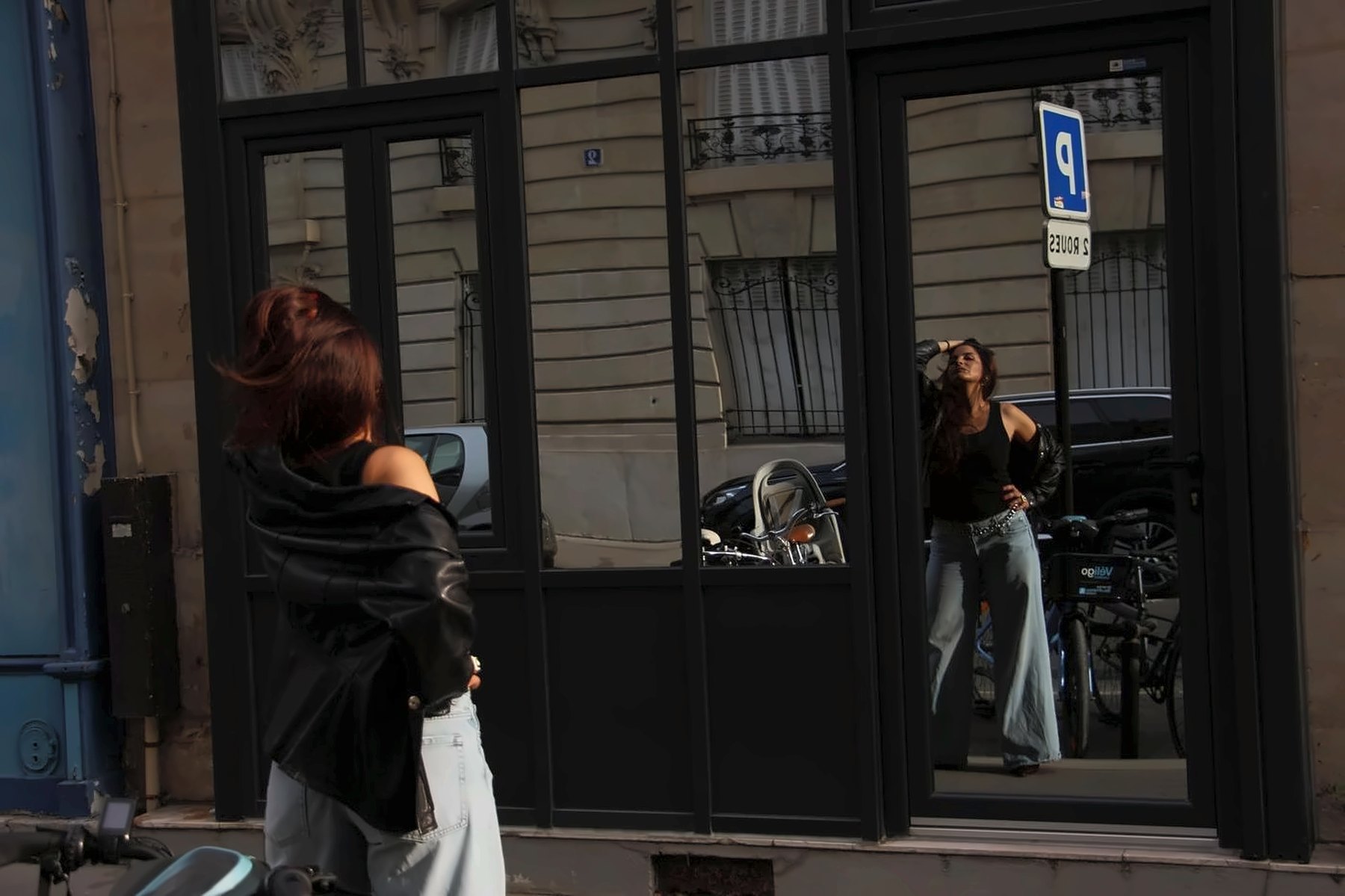 SEYA devant une vitrine, reflet dans la rue